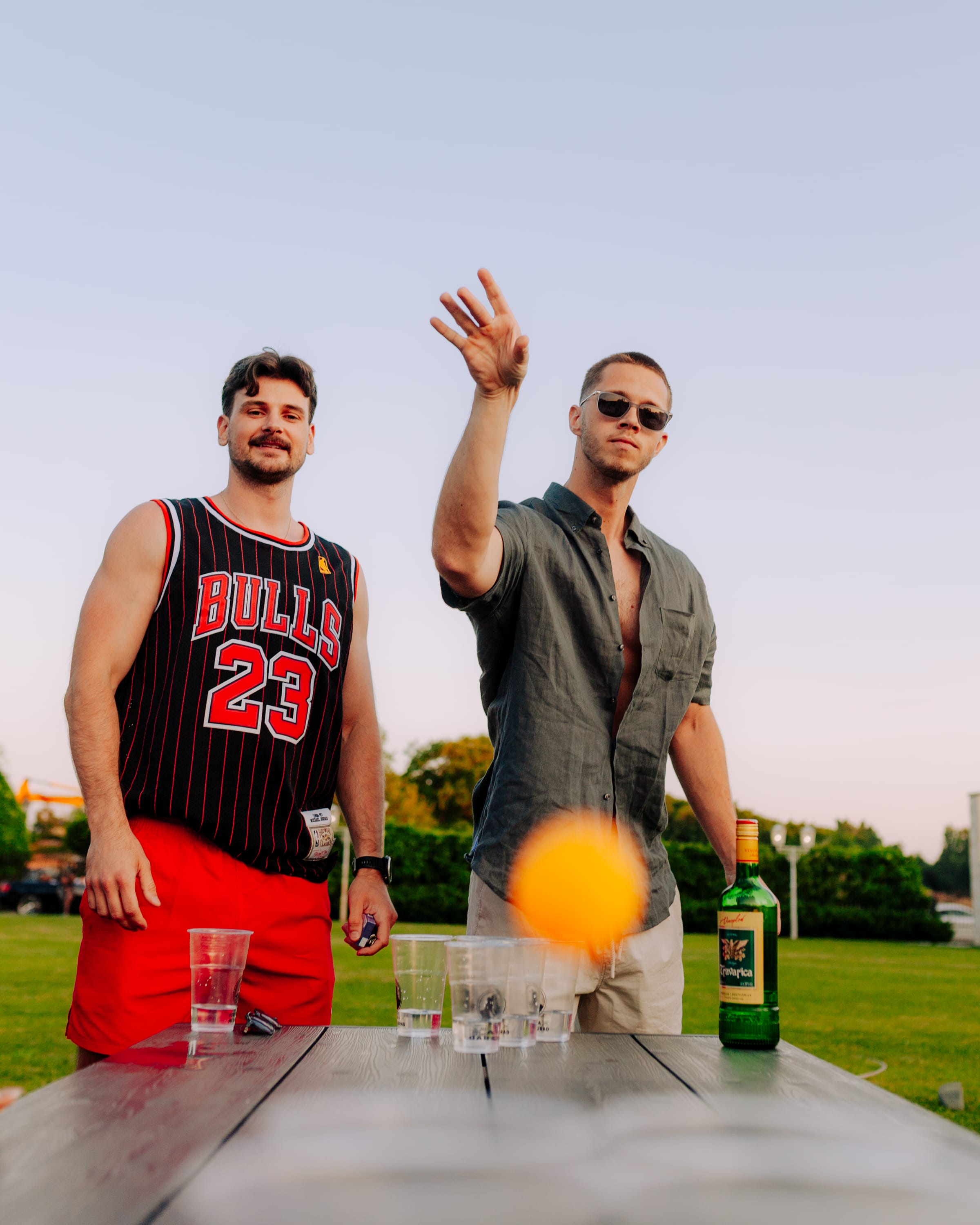 Dvojica prijatelja igraju beer pong na zabavi na otvorenom